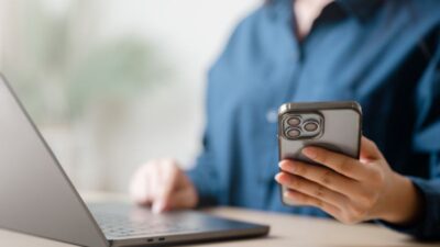 Pessoa usando cartão em maquininha para pagamento de boleto com app no celular exibindo opções de parcelamento