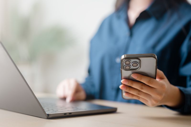 Pessoa usando cartão em maquininha para pagamento de boleto com app no celular exibindo opções de parcelamento