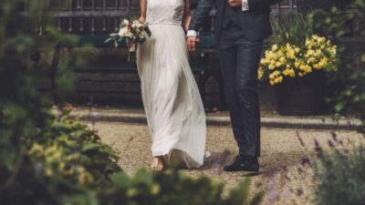 Casal jovem sentado à mesa planejando casamento usando o aplicativo Nova no tablet com cartões de crédito ao lado