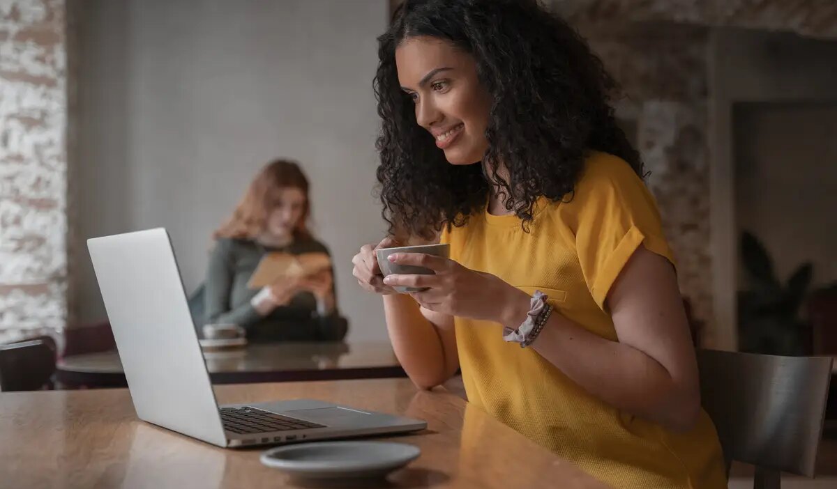 Medium shot women with laptop in coffee shop
