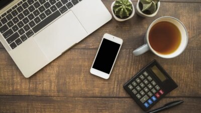 Workspace with laptop and smartphone near tea cup