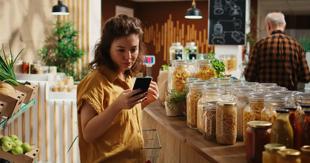Woman uses phone in zero waste shop